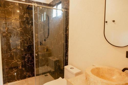 a bathroom with a shower and a sink and a toilet at Mykonos Beach House Apartamentos By Jerusalema in Tolú