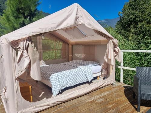a bed in a canvas tent on a deck at La tente de Cléa in Salazie