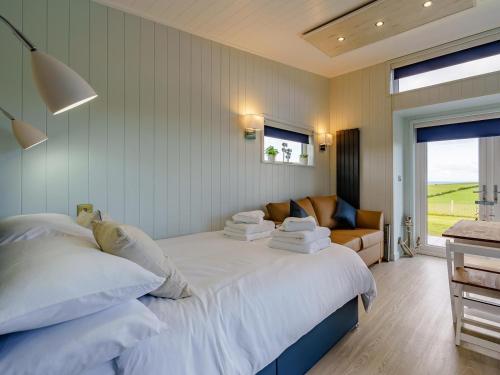 a bedroom with a large white bed and a couch at 1 Bed in Girvan oc-78072 in Girvan