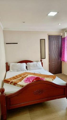 a bedroom with a large bed with a wooden frame at Close2heaven 3 bedroom privacy Home with a hall and a paid kitchen in Kodaikānāl