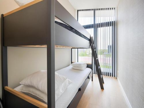 a bedroom with a bunk bed and a large window at Polder in Oud-Ade