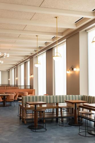 a waiting room with tables and chairs and windows at Virginia Guesthouse at University of Virginia in Charlottesville