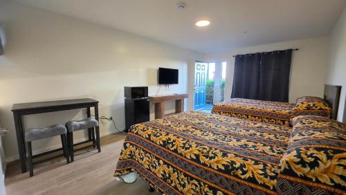 a hotel room with two beds and a television at Sierra Crossing Motel in Bloomington