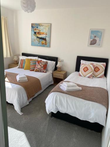 two beds sitting next to each other in a bedroom at Simla Bungalow, Tetney, Spacious Parking, Private Garden in Tetney