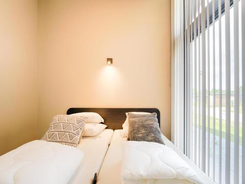 two beds in a room with a window at Strand in Oud-Ade