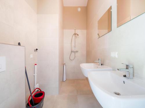 a white bathroom with a sink and a shower at Strand in Oud-Ade