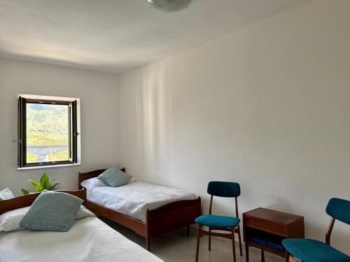 a room with two beds and two chairs and a window at La Scaletta - Charming Historic Center Home - Mountain View in San Nicola Arcella