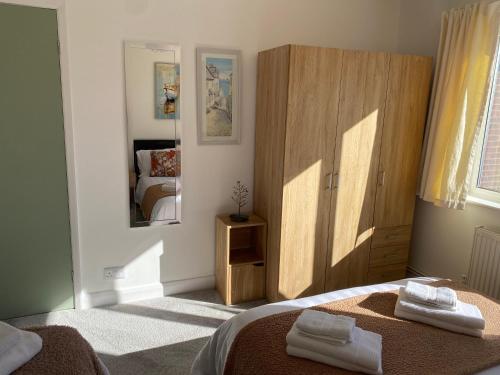 a bedroom with a bed and a wooden cabinet at Simla Bungalow, Tetney, Spacious Parking, Private Garden in Tetney