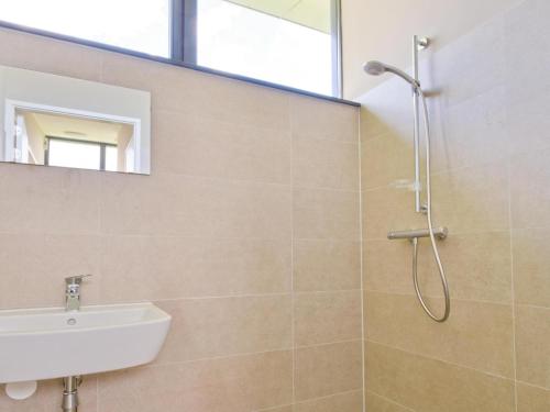 a bathroom with a shower and a sink and a mirror at Kaag in Oud-Ade