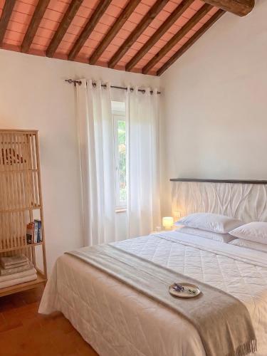 a bedroom with a large white bed with a window at Residenza Castelnovo in Gubbio