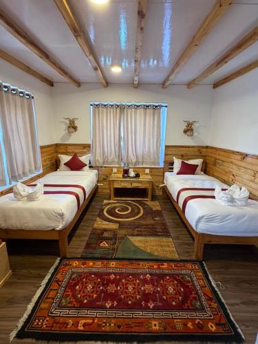 a room with two beds and a rug at Hotel Sheryang in Namche