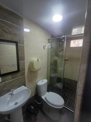 a bathroom with a toilet and a sink and a shower at HOTEL DULCES SUEÑOS in Buenaventura