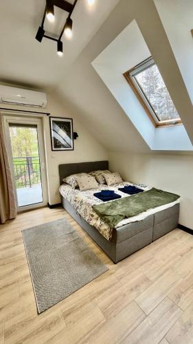 a bedroom with a bed and a vaulted ceiling at Pokoje nad Jeziorem Solina in Solina