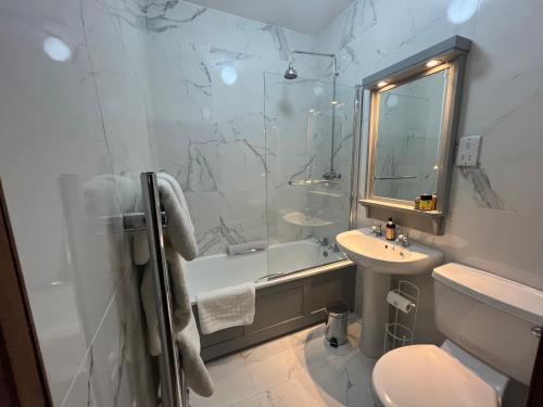 a bathroom with a tub and a sink and a toilet at Wild Honey Inn in Lisdoonvarna