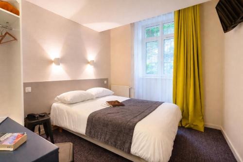 a hotel room with a bed and a window at Hôtel Du Port in Morlaix