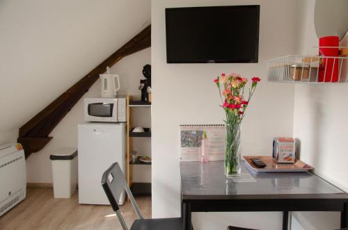 a vase of flowers on a table in a kitchen at Le Relais de Louis in Orbigny
