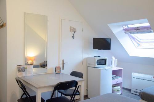 a small room with a table and a microwave at Le Relais de Jeanne in Orbigny