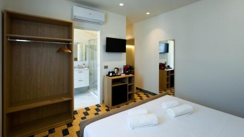 a bedroom with a large white bed and a bathroom at BORGO MARE 86 rooms in Porto SantʼElpidio