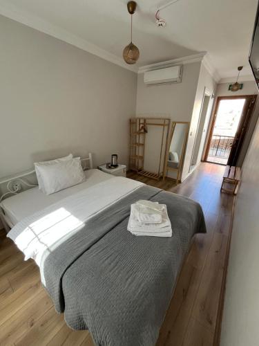 a bedroom with a large bed with a gray blanket at Lokal Ayvalık Guest House in Ayvalık