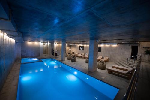 a large swimming pool in a building with blue lighting at Loft & SPA resort ROOMs in Palyanytsya