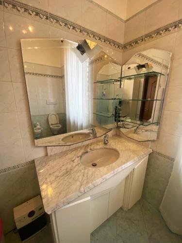 a bathroom with a sink and a large mirror at Suite in Private Villa in Milan