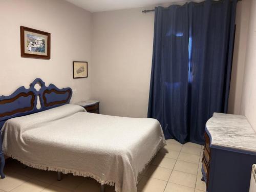 a bedroom with two beds and a blue curtain at cerronegro con terraza in Capileira