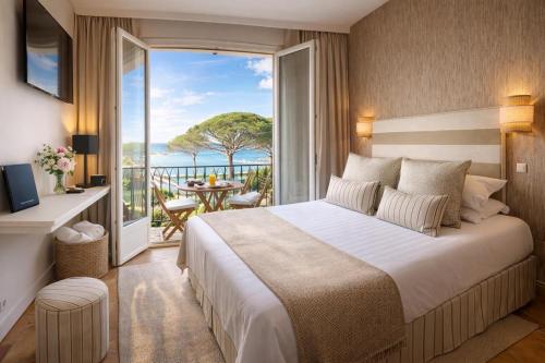 a bedroom with a bed and a view of the ocean at La Bastide Du Port - Hôtel de Charme in Saint-Tropez