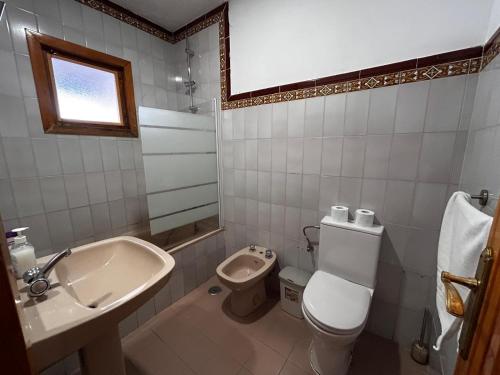 a bathroom with a white toilet and a sink at cerronegro con terraza in Capileira