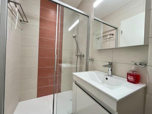 ein Badezimmer mit Waschbecken und Dusche in der Unterkunft HostHelp - Les Balises in Bevaix