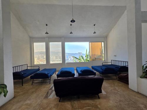 a living room with blue couches and a large window at Casa Horizonte Azul Acapulco in Acapulco