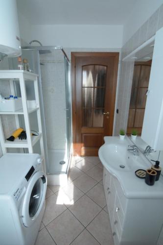 a bathroom with a sink and a washing machine at Casa Verena in Aosta