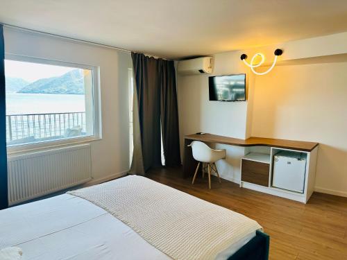 a bedroom with a bed and a desk and a window at NOAH ponton in Orşova