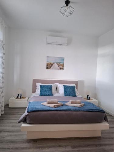a bedroom with a large bed with blue pillows at Varanda Encantada House in Ponta do Sol