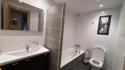 a white bathroom with a sink and a toilet at Mitxelena in Zarautz
