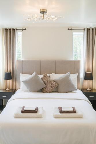 a bedroom with a large white bed with two towels on it at Private Room Near Excel London & City Airport Free Parking Available & WiFi in North Woolwich