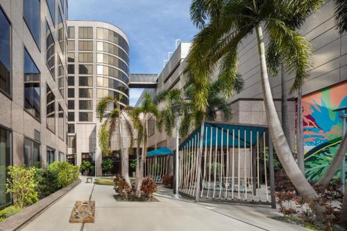 a courtyard with palm trees in front of a building at The Westshore Grand, Tampa, A Tribute Portfolio Hotel in Tampa
