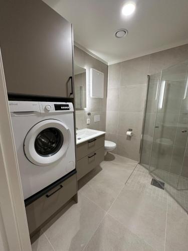 a washing machine in a bathroom with a shower at Motoppen, Høgeggvegen 4B in Trysil
