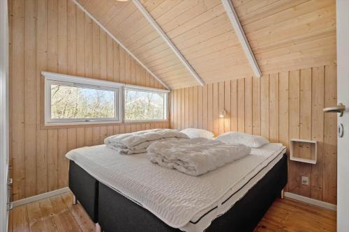 a large bed in a room with wooden walls at VE508-Oksbol-Blomstervangen-123 in Oksbøl