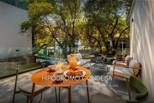 a table with a plate of food and orange juice at Capitalia Hipodromo Condesa in Mexico City