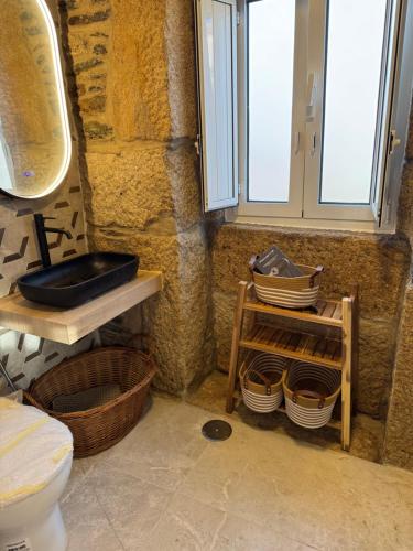 a bathroom with a toilet and a sink and a window at Casa da Prima in Torre de Moncorvo