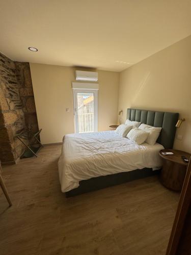 a bedroom with a large bed and a window at Casa da Prima in Torre de Moncorvo