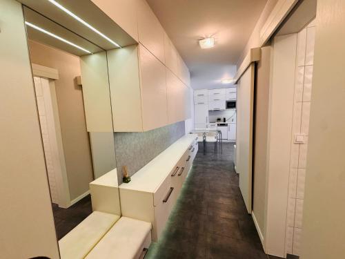 a kitchen with white cabinets and a long counter at Central Seven Apartman - Free Parking in Győr
