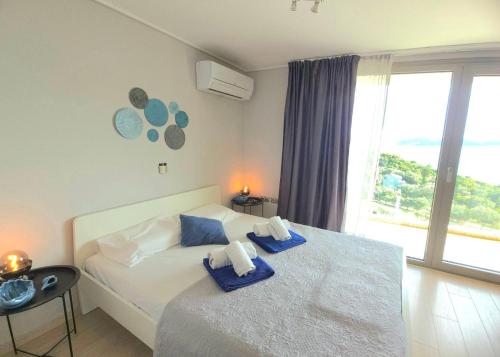 a bedroom with a bed with blue pillows on it at Studio Evian in Paleo Tsifliki