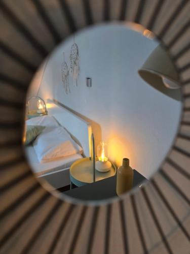 a mirror reflecting a bedroom with a bed and a table at Studio Evian in Paleo Tsifliki