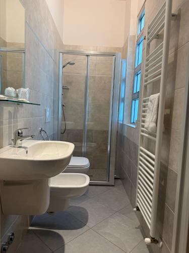a bathroom with a toilet and a sink and a shower at Hotel De La Plage in Rimini