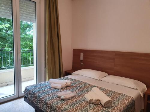 a bedroom with a bed with two towels on it at Hotel De La Plage in Rimini