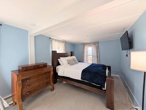 a bedroom with a bed and a dresser and a television at The Saco Valley Stay in Conway