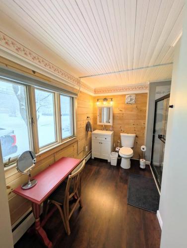 a bathroom with a red table and a toilet at The Saco Valley Stay in Conway