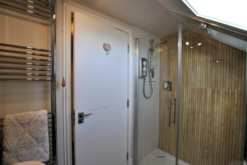 a bathroom with a shower with a glass door at Harbourside Apartment in Anstruther
