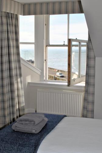 a bedroom with a bed and a window with the ocean at Harbourside Apartment in Anstruther